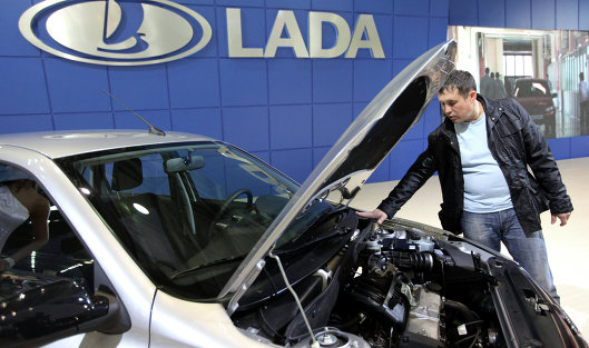 Посетитель осматривает автомобиль Lada Granta