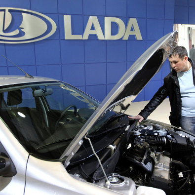 Посетитель осматривает автомобиль Lada Granta