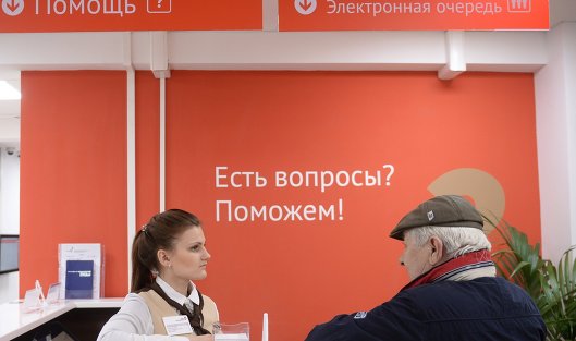 Сотрудница и посетитель центра государственных услуг в Москве