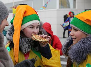 Участники кушают блины во время массового масленичного гуляния "Блинно-сырное веселье" в Белгороде