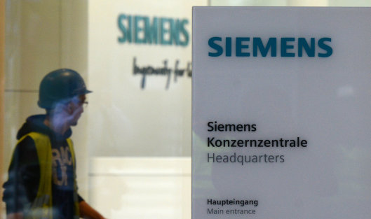 Рабочий у входа в штаб-квартиру компании Siemens в Мюнхене, Германия