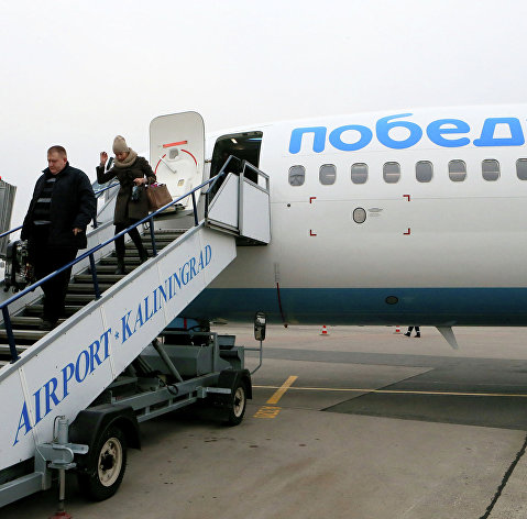 Пассажиры сходят с самолета российской низкобюджетной авиакомпании "Победа", осуществившего первый рейс по маршруту Москва-Калининград