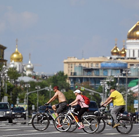 Люди катаются на велосипедах возле Фрунзенской набережной в Москве