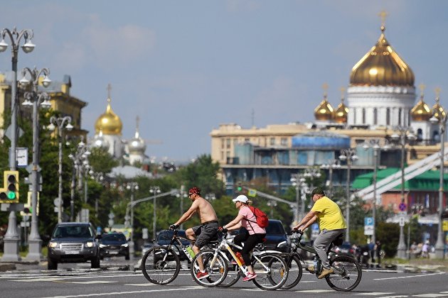 Люди катаются на велосипедах возле Фрунзенской набережной в Москве