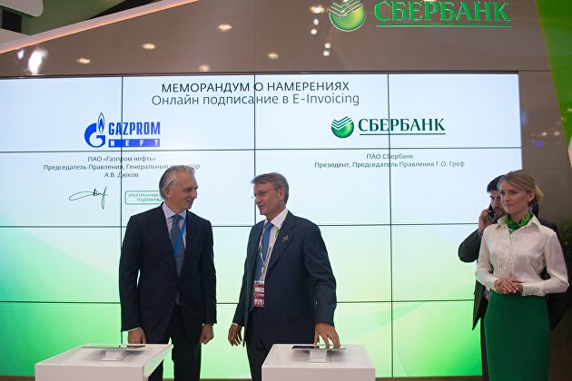 Председатель правления, генеральный директор ОАО "Газпром нефть" Александр Дюков (слева) и президент, председатель правления Сбербанка России Герман Греф во время подписания меморандума о намерениях сотрудничества в рамках XX Петербургского международного экономического форума.