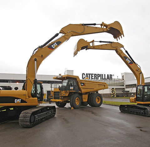 Дорожно-строительная техника Caterpillar у здания завода компании