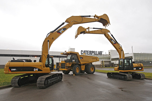 Дорожно-строительная техника Caterpillar у здания завода компании